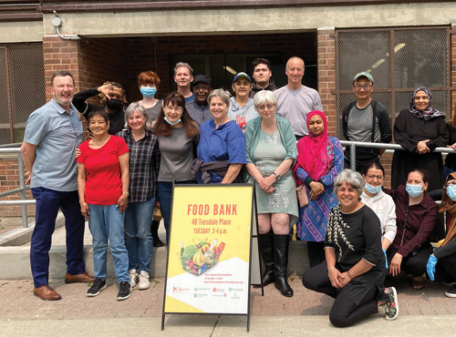 group of people posing in front of food bank