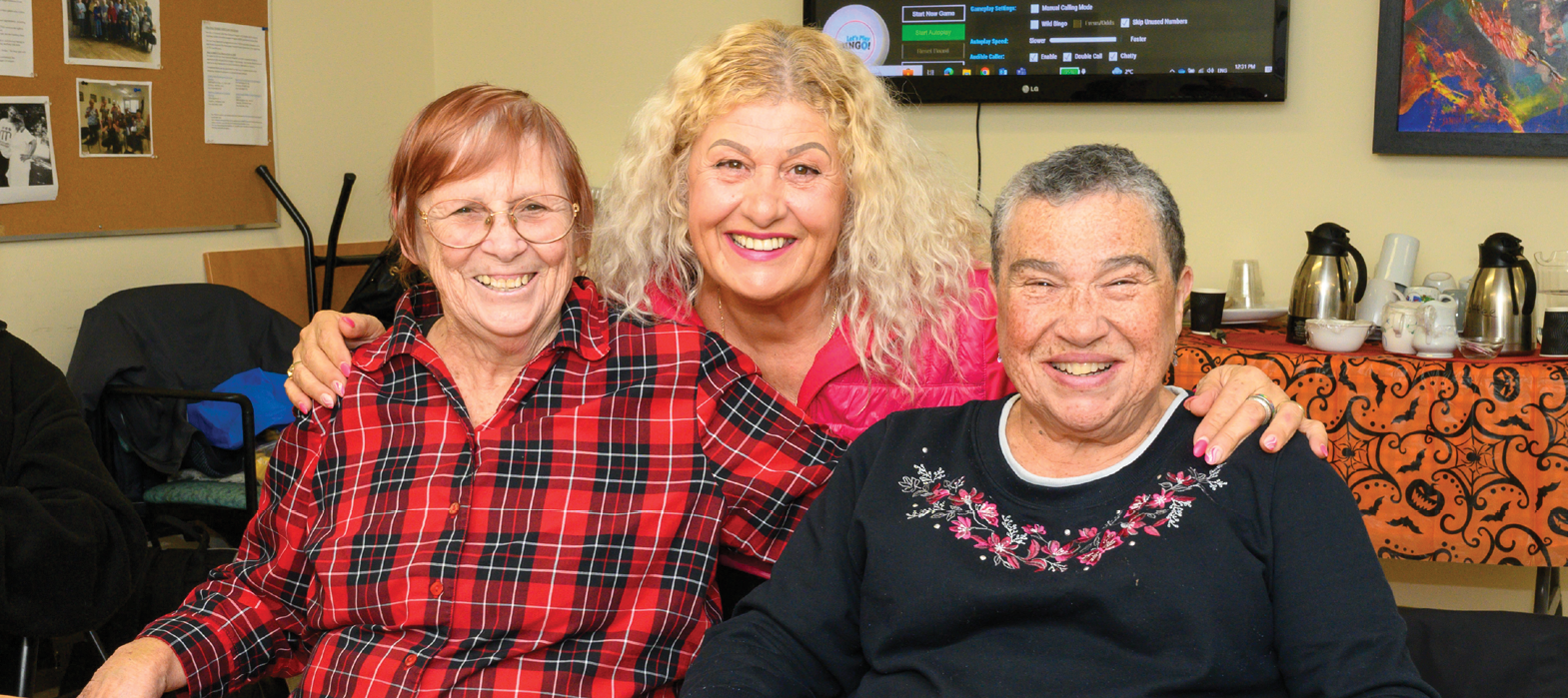 smiling personal support worker with two seniors