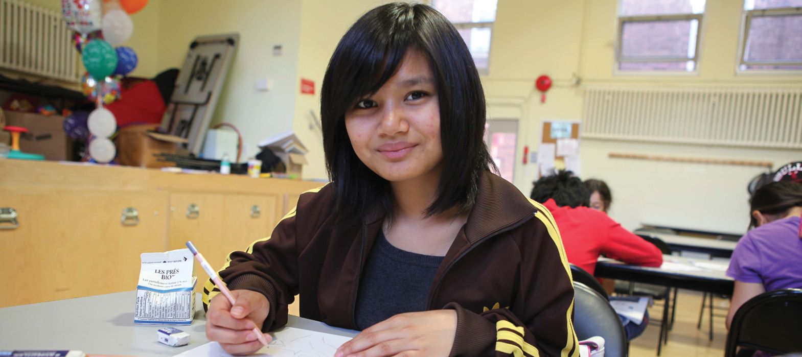 young girl sitting at a table doing homework