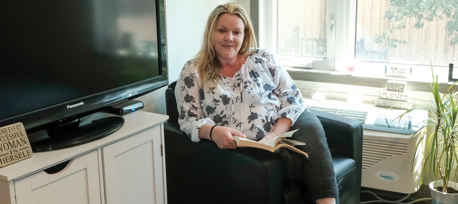 smiling woman sitting in her apartment