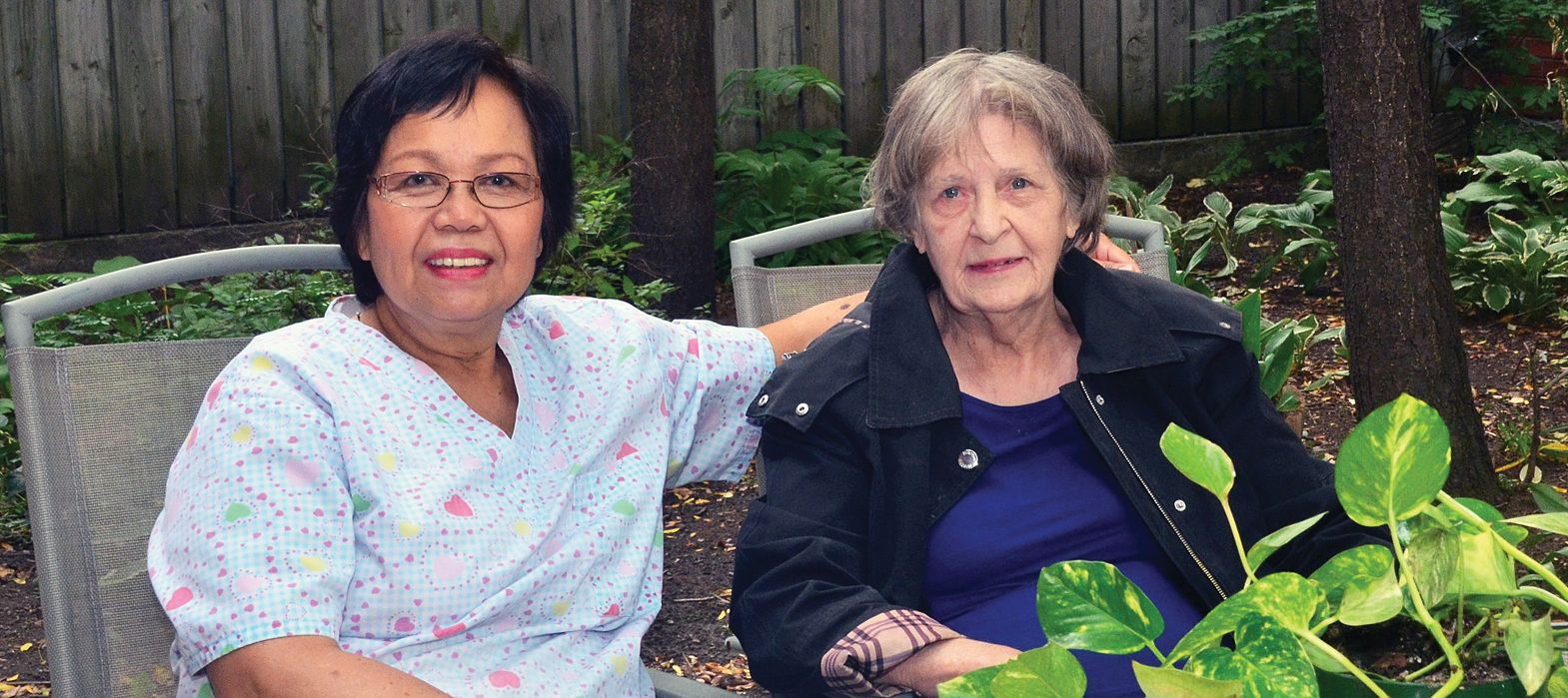 smiling senior sitting next to an elderly woman