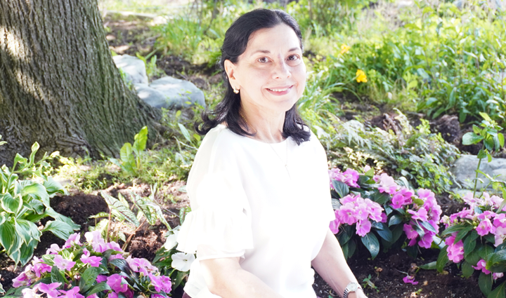smiling woman sitting in front of flowers