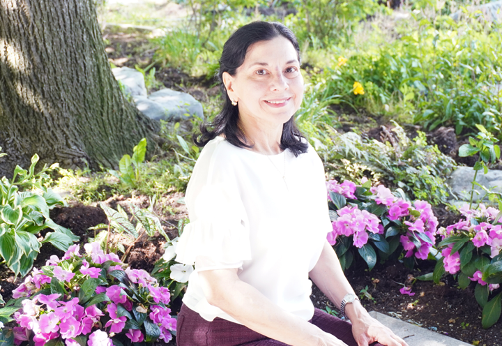 smiling woman sitting in front of flowers