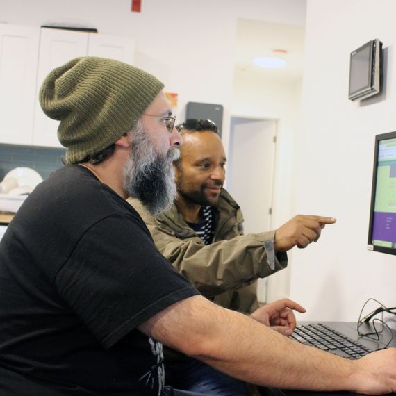 two men sitting and working on a computer