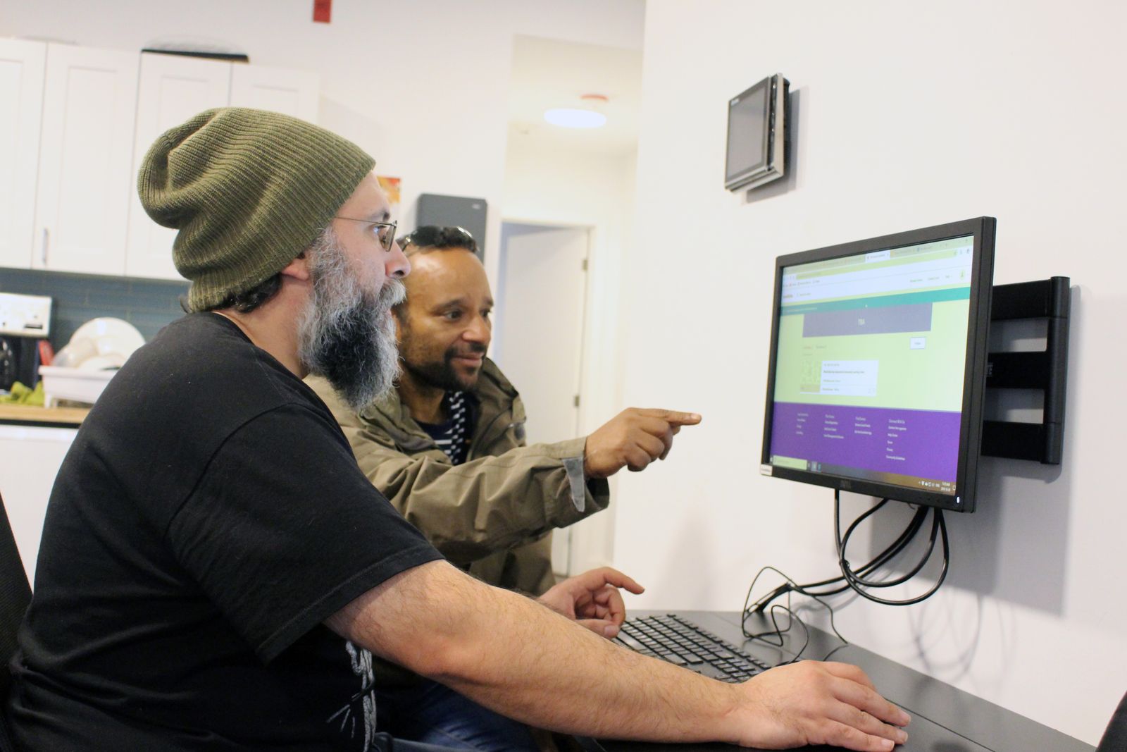 two men sitting and working on a computer