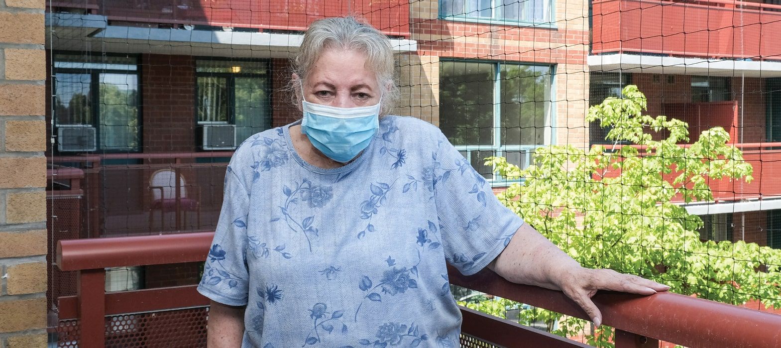 elderly woman standing on balcony