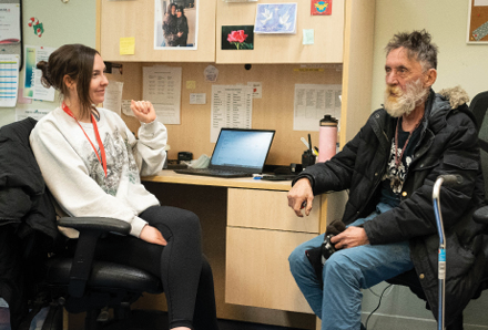 woman talking with elderly man in office