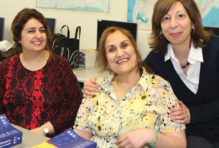 three smiling women in a classroom