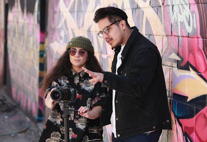 Woman standing behind camera wit man standing next to her