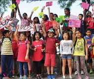 group of children and caregivers holding protest signs