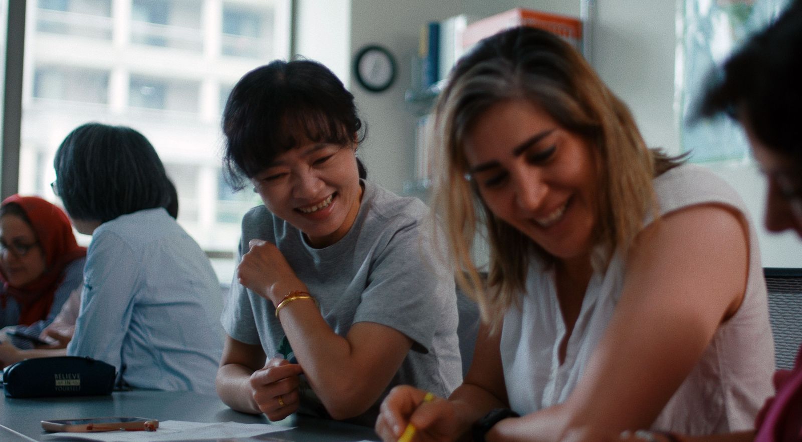 two smiling women in a classroom