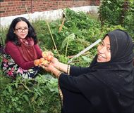 two women holding veggies