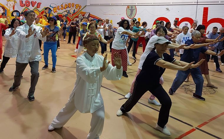 seniors and friends doing Tai Chi in a gym