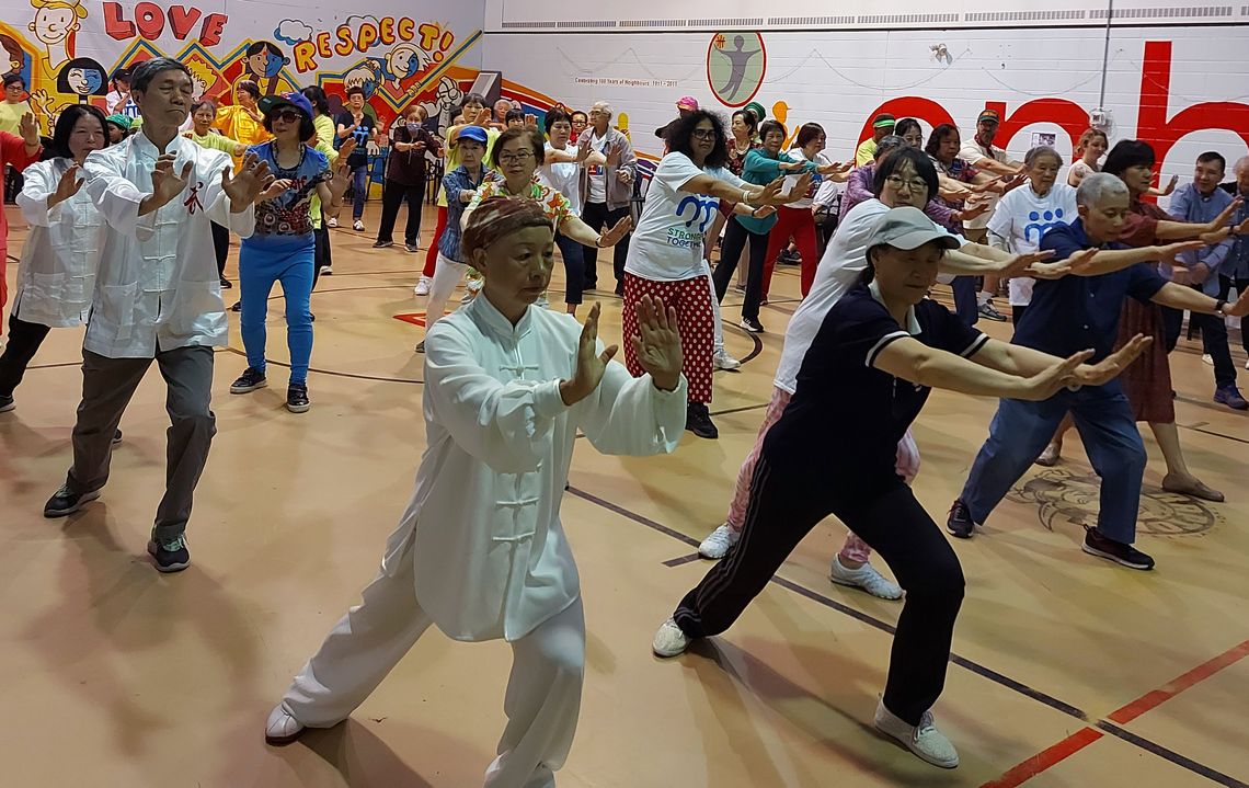 seniors and friends doing Tai Chi in a gym